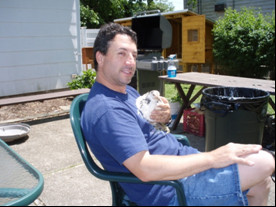 man sitting holding a chicken